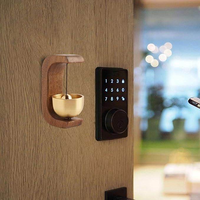 Close-up of beech wood and brass doorbell showing artisan craftsmanship and natural wood grain